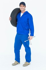 Poster - Confident mechanic carrying tire