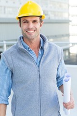 Poster - Smiling male architect holding blueprint
