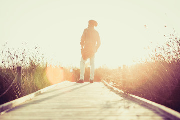 urban man walking on a catwalk in the field enjoying nature