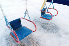 Snow Covered Swing And Slide At Playground In Winter