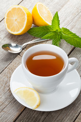 Green tea with lemon and mint on wooden table