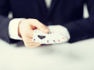 man hand showing four aces