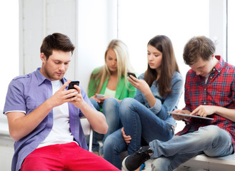 Wall Mural - students looking into devices at school