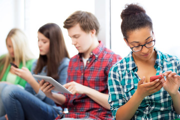 Wall Mural - students looking into devices at school
