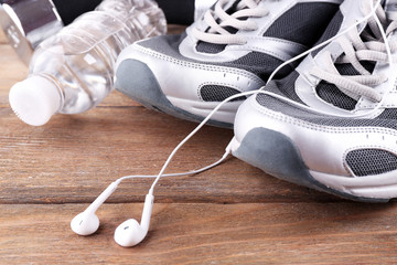 Wall Mural - Sport shoes and bottle of water on wooden background