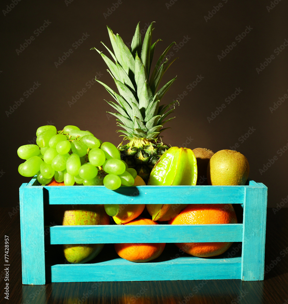 Assortment of fruits in box on dark background