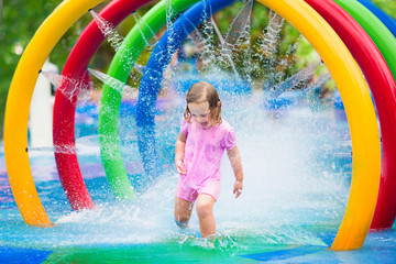 Little girl playing with fountain