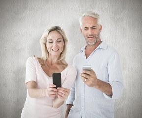 Leinwandbilder - Composite image of happy couple texting on their smartphones