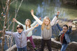 Niños junto a río levantando los brazos