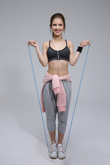 Wall Mural - Full length portrait of a happy sporty woman with skipping rope