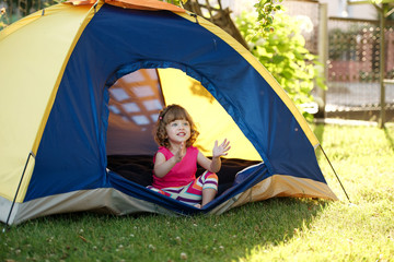 Wall Mural - little girl sitting in colorful tent