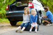 © MNStudio - Happy family changing a car wheel