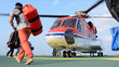 passenger carry his baggage to embark helicopter at oil rig plat