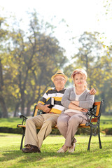 Poster - Mature couple relaxing seated on a bench in park