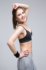 Poster - Portrait of a smiling sporty woman over gray background