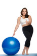 woman is overweight with blue ball fitness