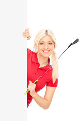 Poster - Female golfer posing behind a blank billboard