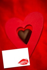 Composite image of chocolate love heart and red paper heart