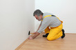 © sima - Laminate flooring of room worker hammer batten, pound in nail