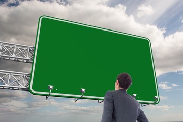Poster - Composite image of businessman standing with hand on hip