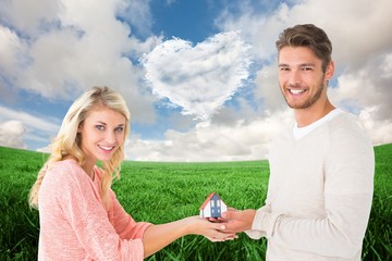 Poster - Attractive couple holding miniature house model