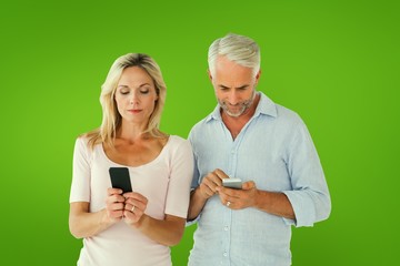 Leinwandbilder - Composite image of happy couple texting on their smartphones