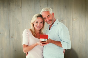 Poster - Composite image of happy couple holding miniature model house