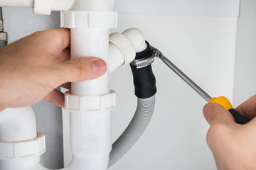 Plumber Repairing Sink In Bathroom