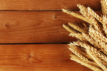 Poster - Spikelets of wheat on wooden background