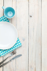 Poster - Empty plate, silverware and towel over wooden table background