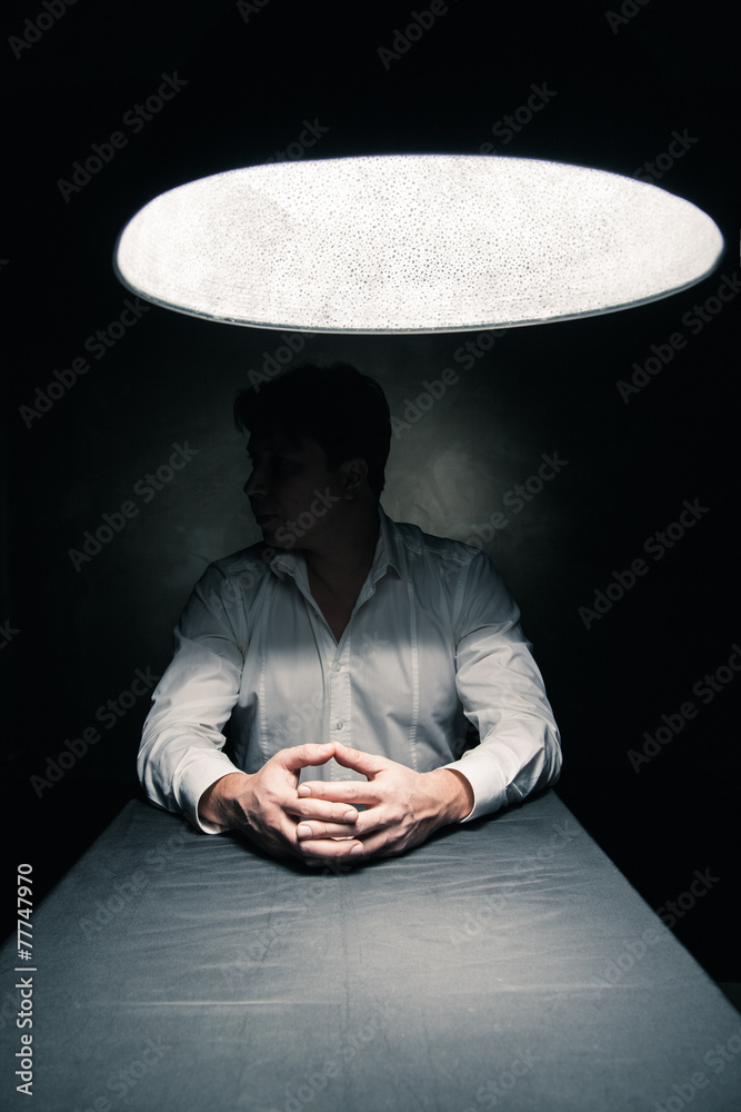 Man in a dark room illuminated only by lamp - obrazy, fototapety, plakaty 