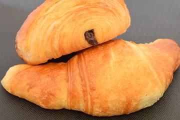 Two fresh croissants.on a black background.