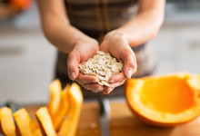 Closeup On Young Housewife Showing Pumpkin Seeds