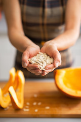 Wall Mural - Closeup on young housewife showing pumpkin seeds