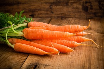 Wall Mural - fresh carrots bunch on wood