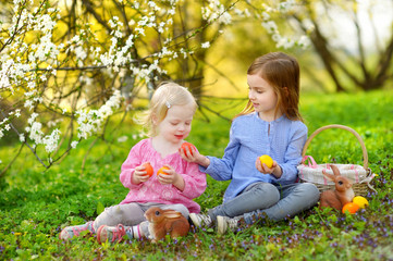 Wall Mural - Two little girls playing in a garden on Easter