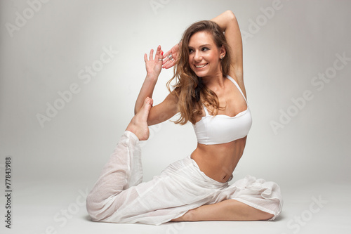 Vászonkép Young woman in yoga pose in studio on white background