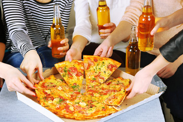 Poster - Friends hands with bottles of beer and pizza, close up