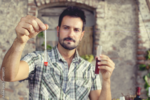 Fotografía expert oenology measuring the percentage of sugar of the wine
