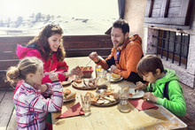 Family Having Lunch In A Chalet In Mountain