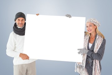 Aufkleber - Smiling couple in winter fashion holding poster