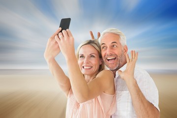 Poster - Composite image of happy couple posing for a selfie