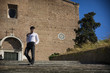 © theartofphoto - Young man walking down old stair in front of church in Rome,