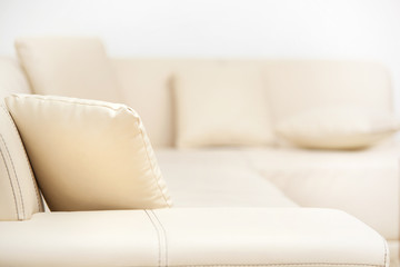 Beige leather sofa with pillows in the living room