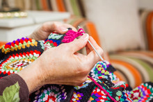 Hands Of Woman Knitting A Vintage Wool Quilt