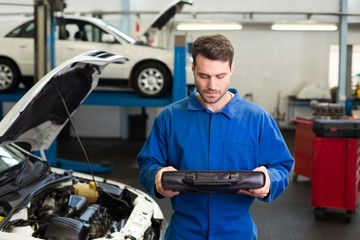 Poster - Mechanic examining under hood of car