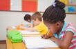 © WavebreakMediaMicro - Cute pupils writing at desk in classroom