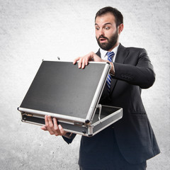 Young businessman open his briefcase over white background