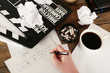 © Africa Studio - Female hand writing script at desktop with moving clapper and