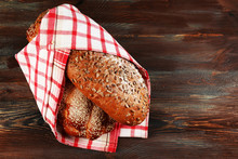 Fresh Breads With Bun With Napkin On Wooden Table Close Up